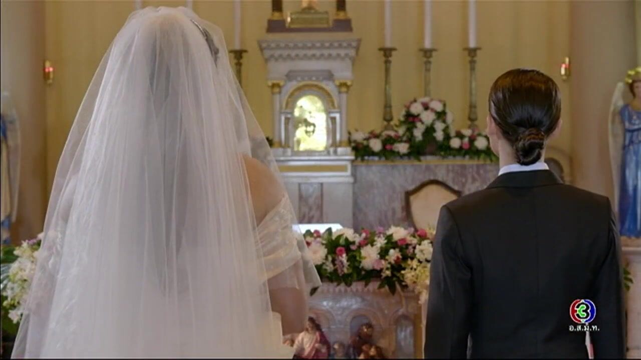 Man wears wedding dress and veil and his wife wears Groom's suit